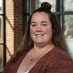 Marissa Finch stands in front of a window overlooking the courtyard.