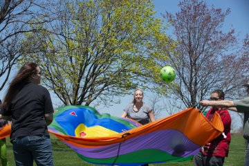 Occupational Therapy students at work with parachute and ball.