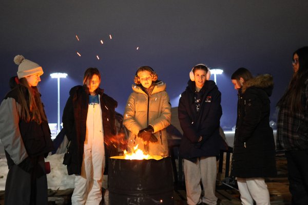 Members of the Chi Beta Sigma sorority warm near a fire as they brave the cold for the Deep Freeze 2025 fundraiser.